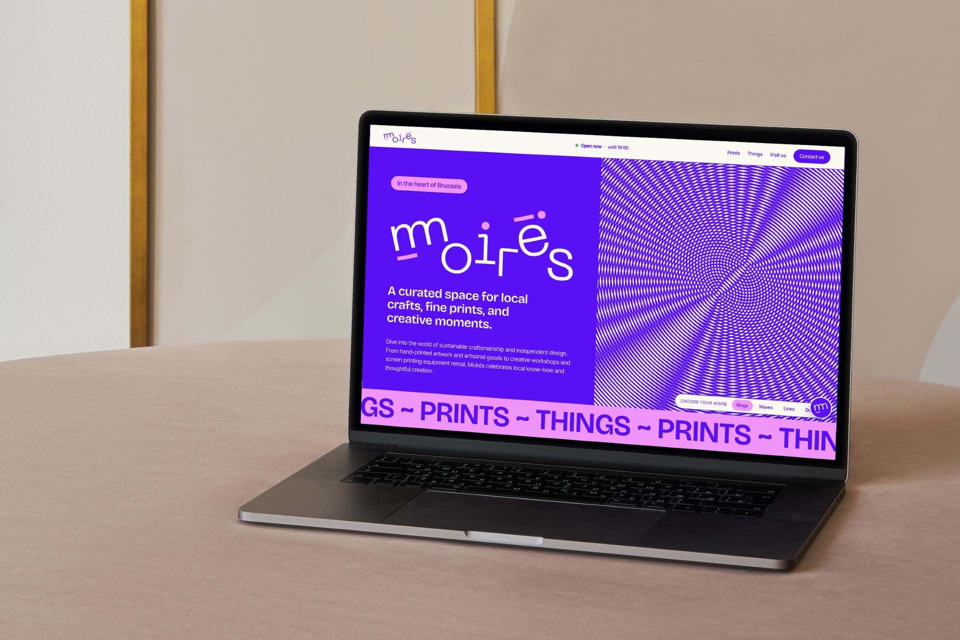 The Moirés home page on a laptop: the wordmark in white on violet beside a moiré pattern, over a pink band repeating prints and things.